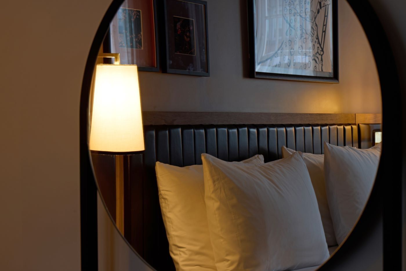 A cozy bed with white pillows and a lit lamp, reflection of a Collection Superior Bedroom in the mirror at The May Fair Hotel, London..