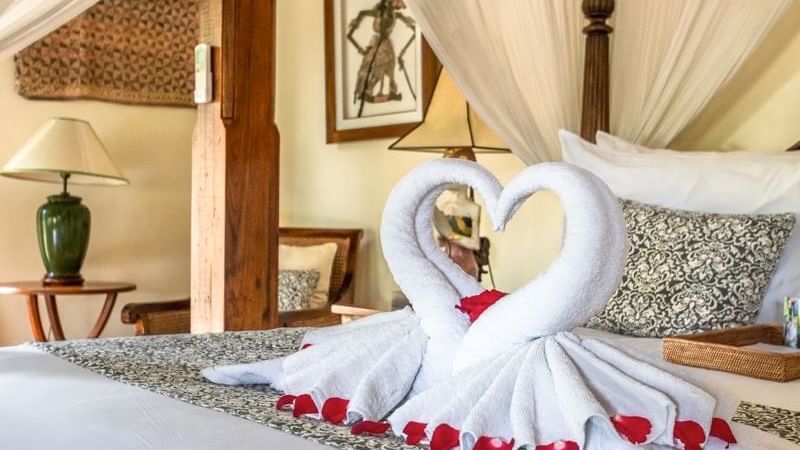 Close-up of towel swans on a bed at Warwick Ibah Luxury Villa