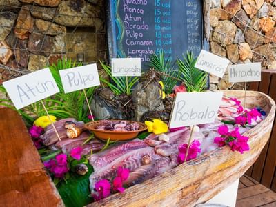 Fish for sale with name boards & flowers at Cala de Mar