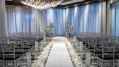 banquet room set with grey chairs and décor set for wedding cere
