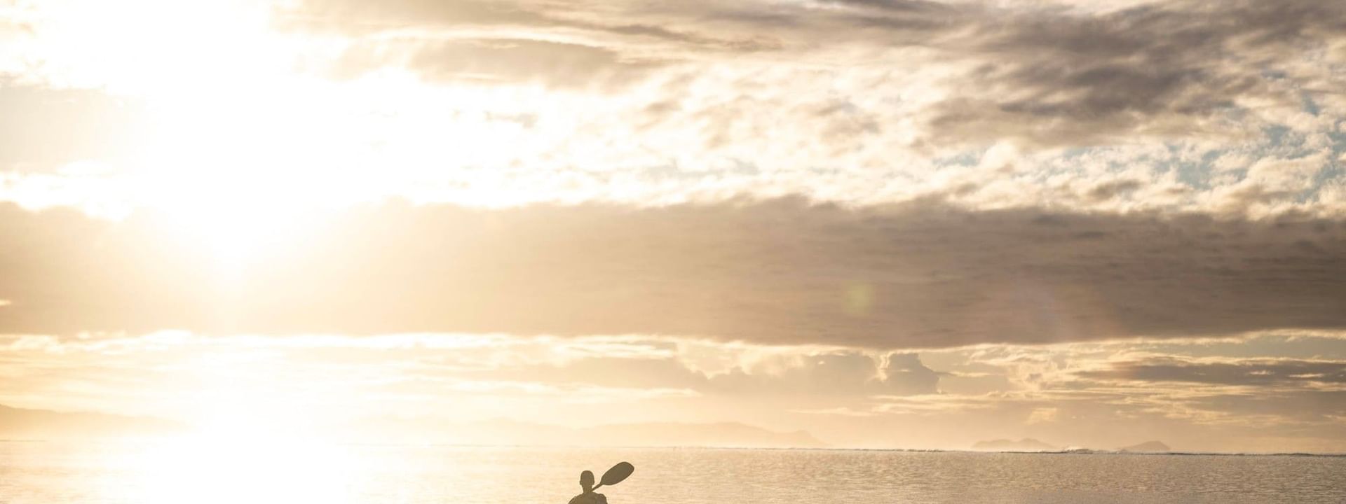 Silhouette of a kayaker enjoying the sunset on water at Warwick Fiji Resort and Spa in Korolevu