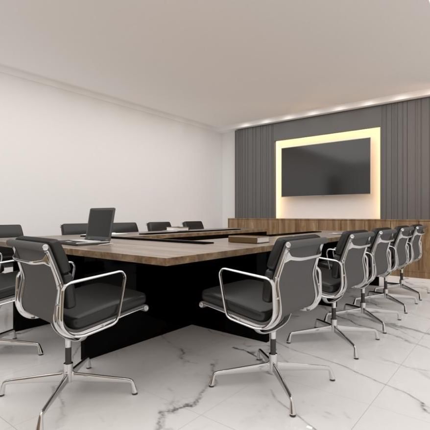 Black leather chairs by a wooden table under a large wall-mounted monitor in Orchid 1 at Cantonal Hotel by Warwick Riyadh