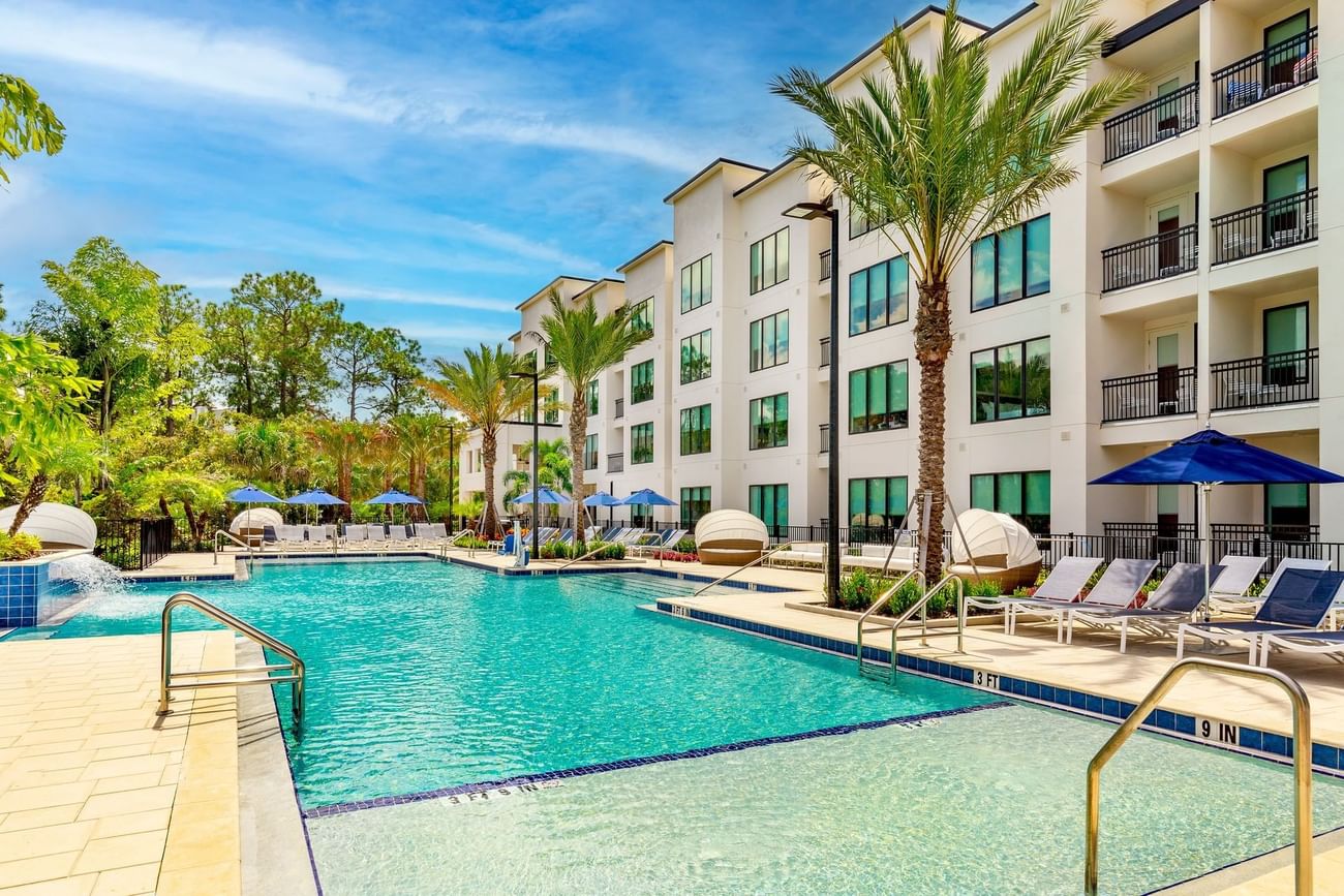 Exterior view of The Grove Resort & Water Park during daytime with outdoor pool, loungers and umbrellas