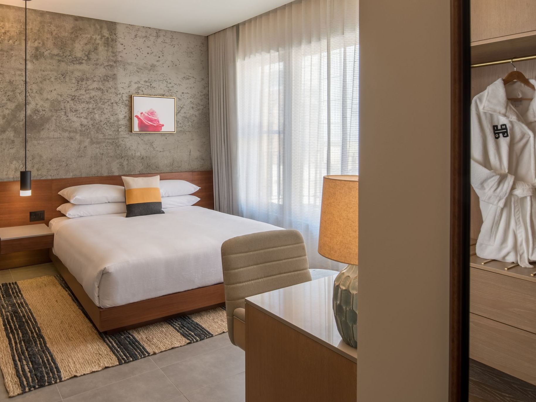 Hi-Lo hotel room with bed and robe in closet