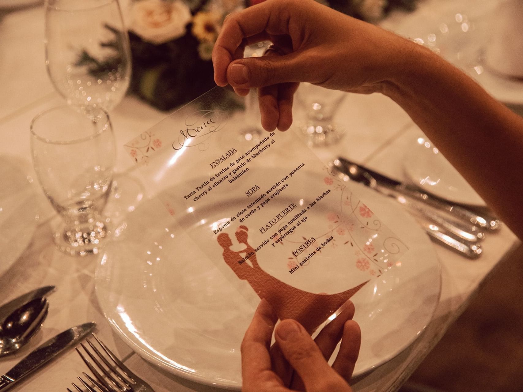 Guest reading a card on dining table at La Coleccion Resorts