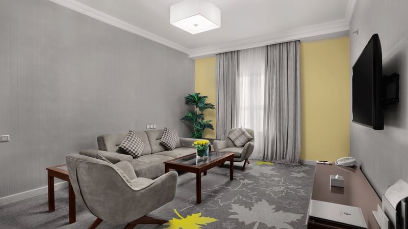 Arranged seating in the living area with carpeted floors of Executive 1 Bedroom Suite at Warwick Hotel Jeddah