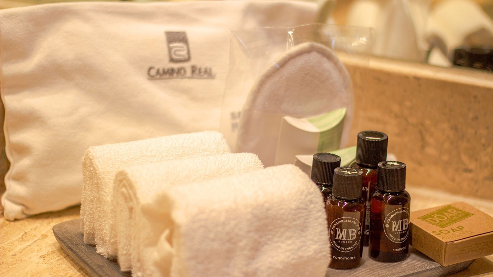 Molton Brown bathroom amenities by rolled towels on a tray in the 2 Double Camino Real Club at Camino Real Aeropuerto Mexico