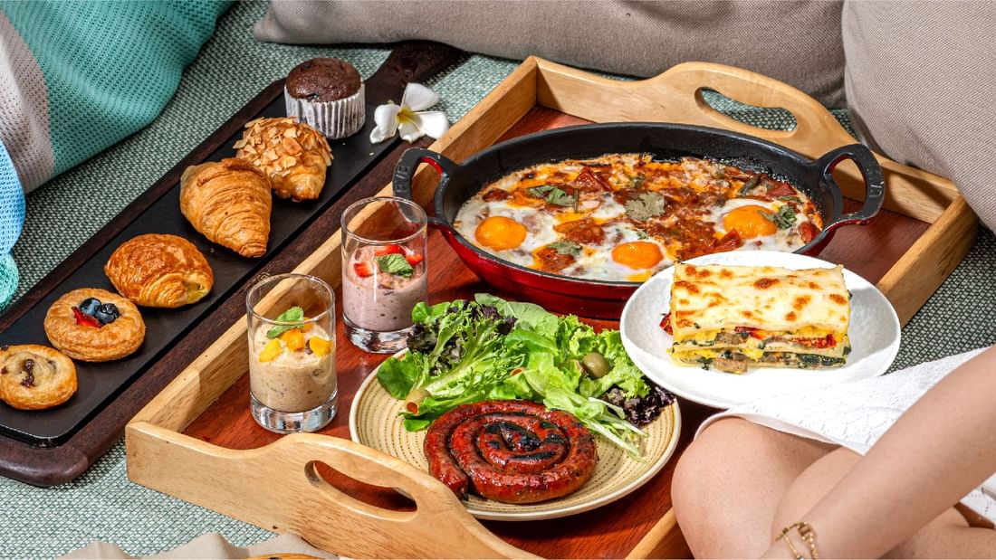A delightful in-room dining breakfast tray at Sunway Hotel Pyramid, featuring pastries, eggs, and sausage