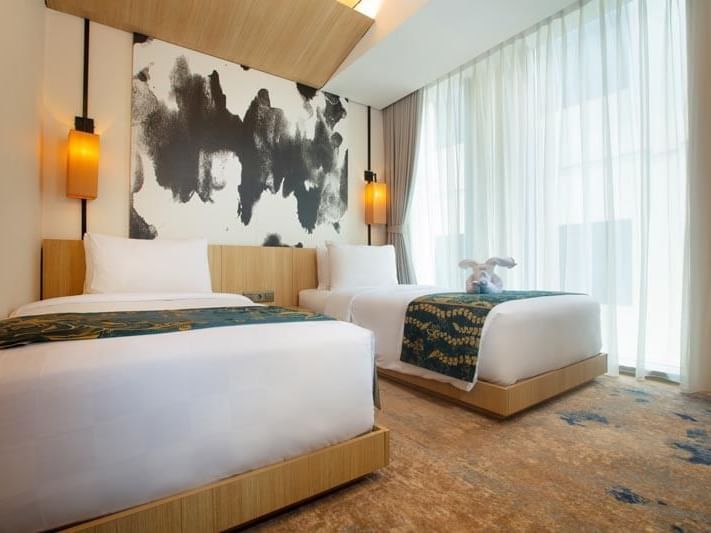 Beds and nightstand in Twin Deluxe Room at LK Cikarang Hotel & Residences