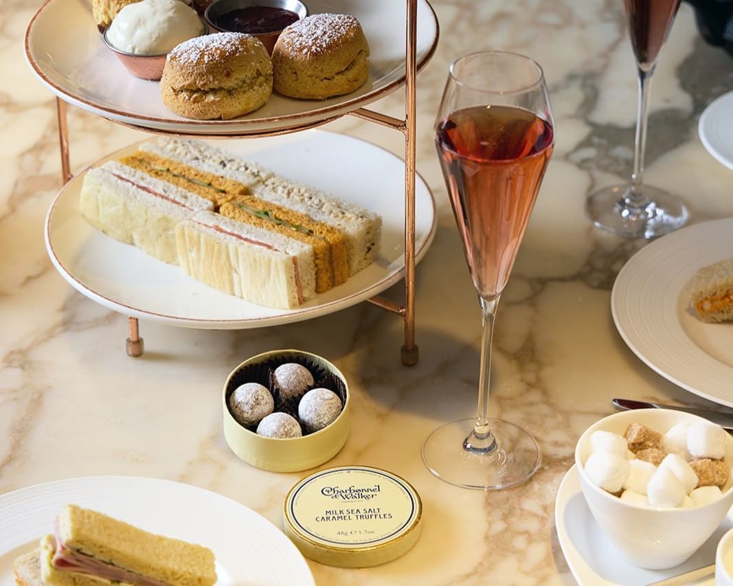 Delicious afternoon tea setup featuring sandwiches, and Charbonnel et Walker chocolates at The May Fair Hotel