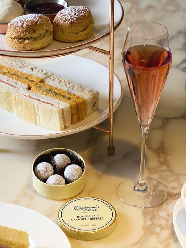 Delicious afternoon tea setup featuring sandwiches, and Charbonnel et Walker chocolates at The May Fair Hotel