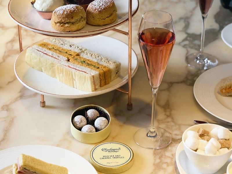 Delicious afternoon tea setup featuring sandwiches, and Charbonnel et Walker chocolates at The May Fair Hotel