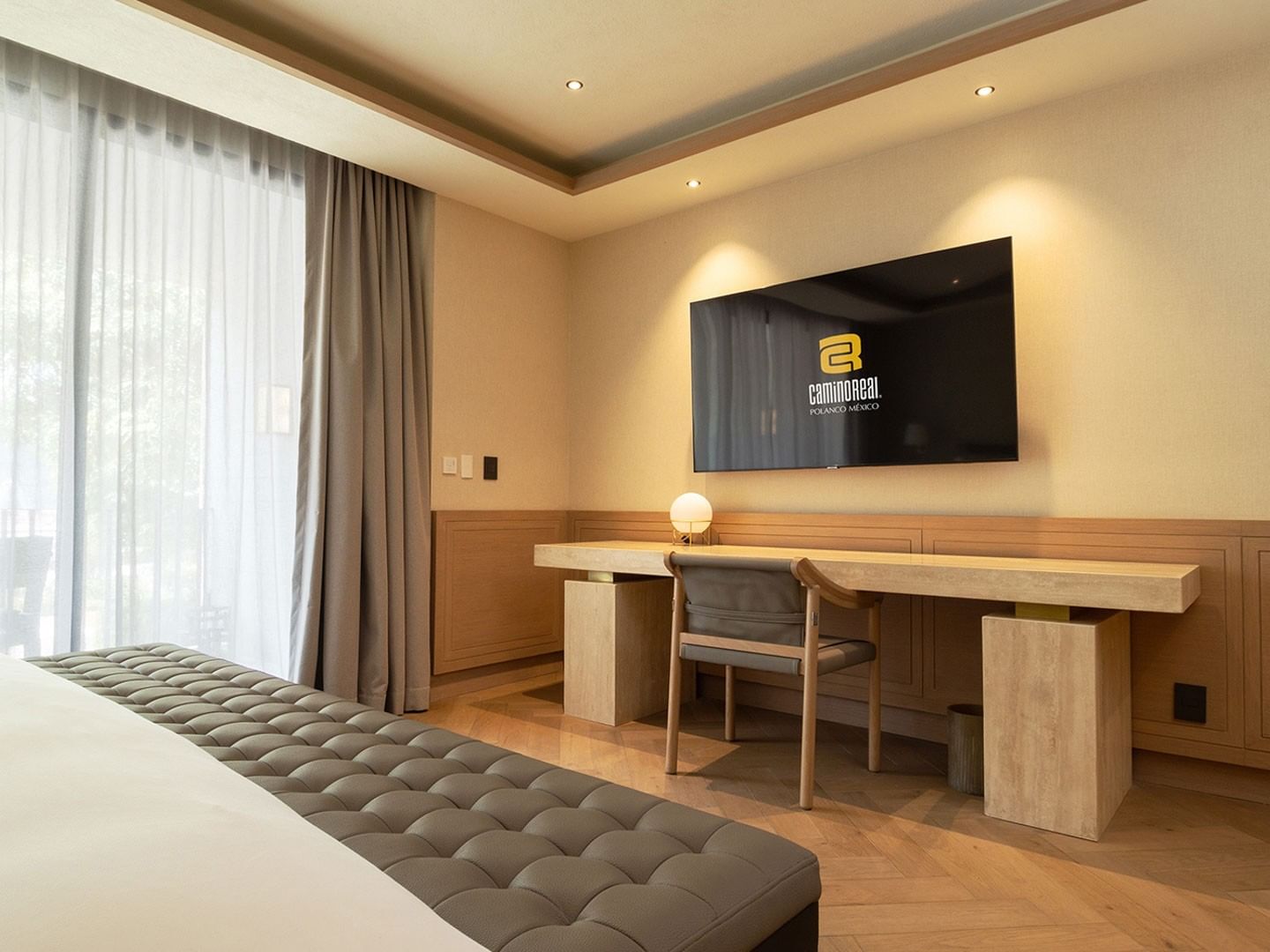 King Superior Viceroys Suite desk and TV featuring wood accents and sleek parquet flooring at Camino Real Polanco Mexico