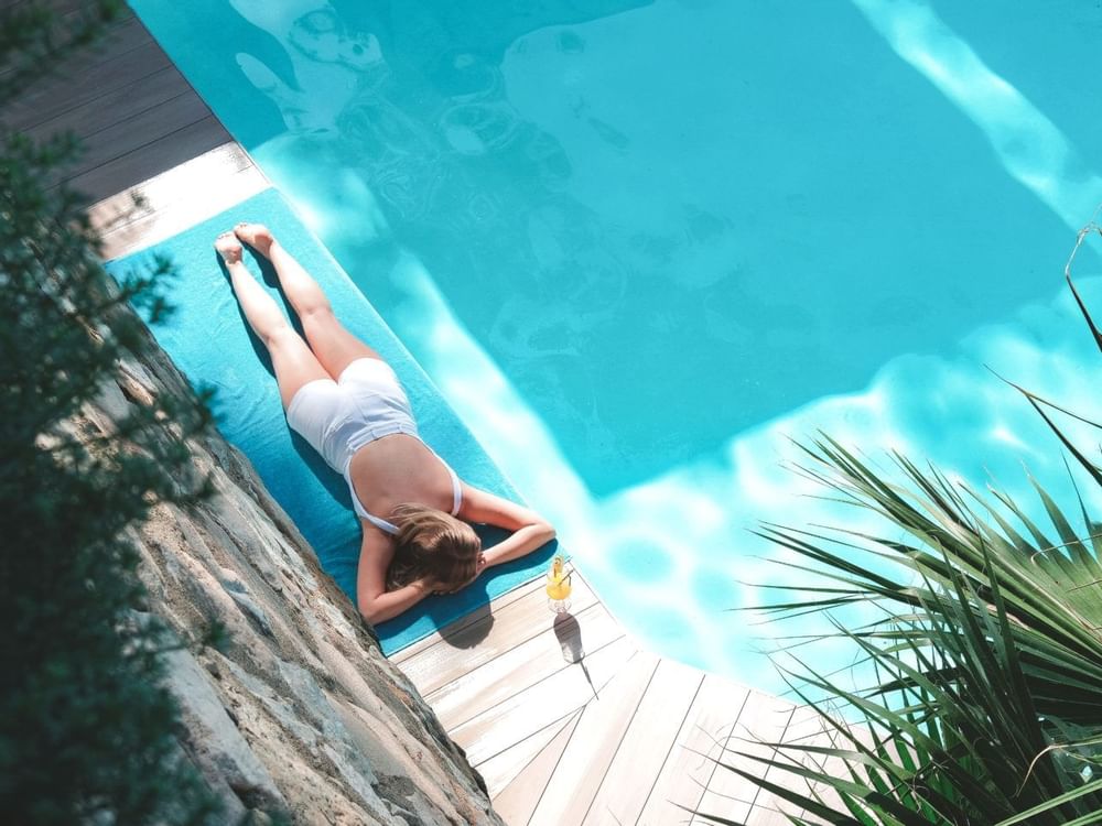 A lady laying & relaxing by the pool at Marbella Club Hotel