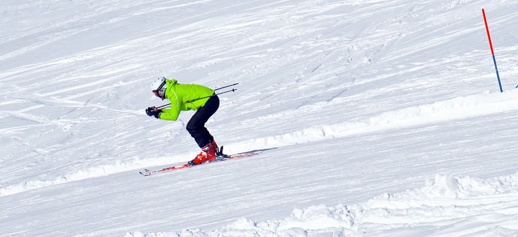 Skier racing downhill in a tucked position
