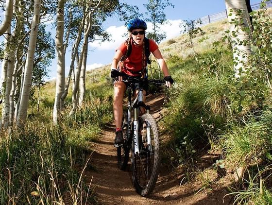 Mountain biker on a ride through a path near Chateaux Deer Valley