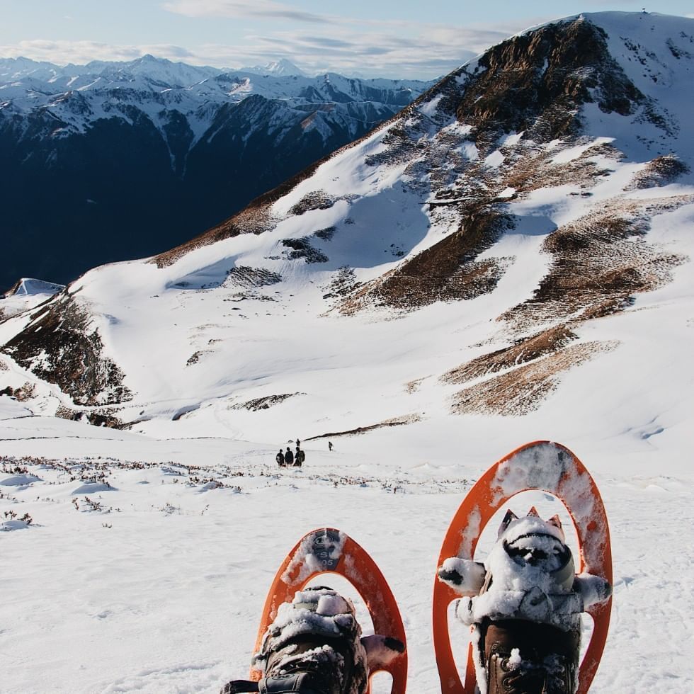 Snowshoes on the snow with mountains near Falkensteiner Hotels