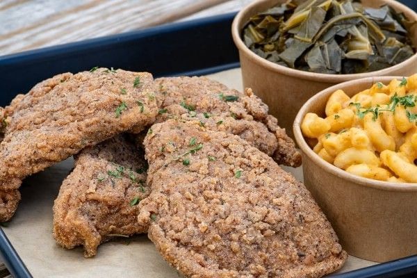 A platter of vegan fried chicken with sides of collard greens and macaroni and cheese from Soulicious Vegan Kitchen in Orlando.