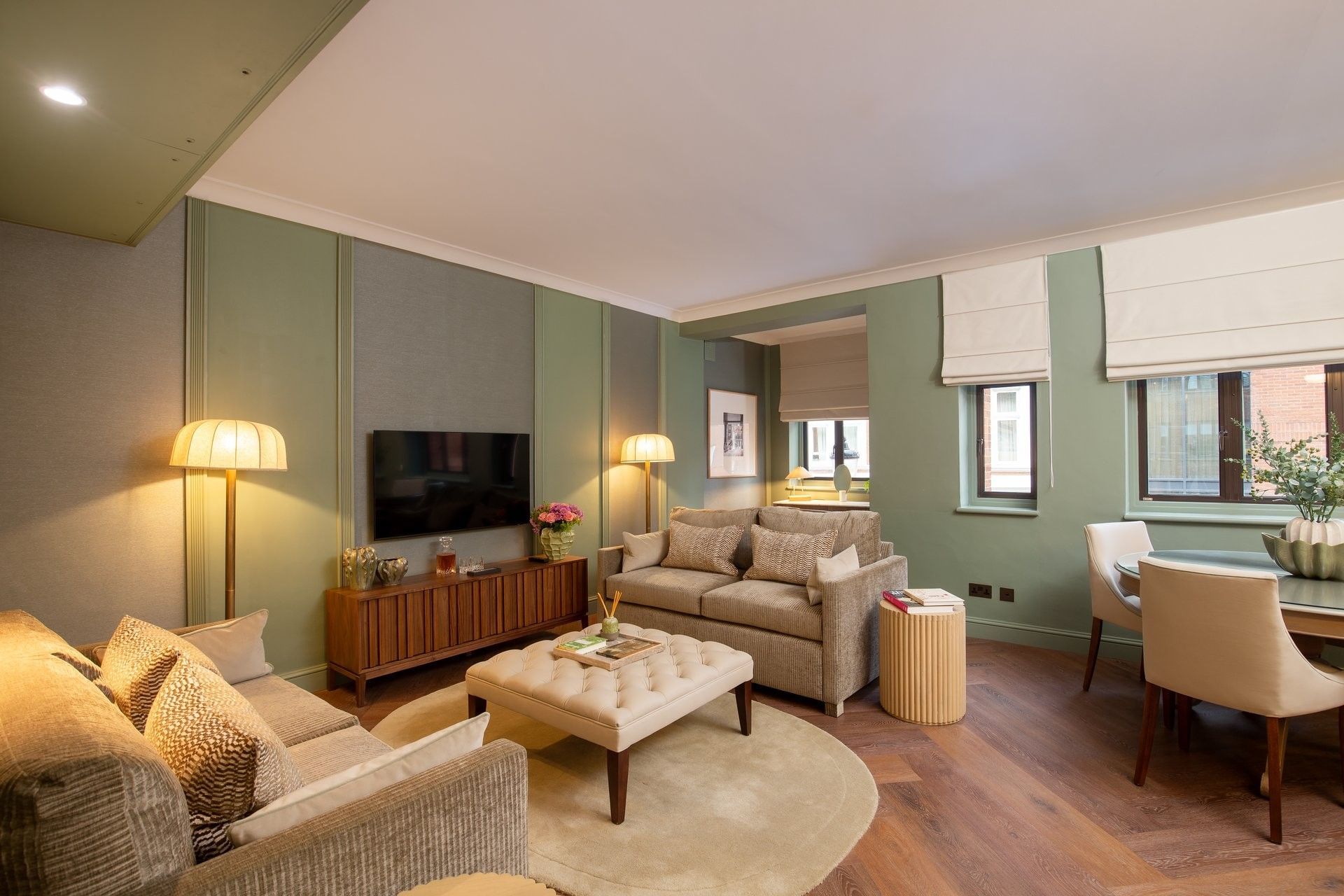 Dining table placed by a wall art in Two Bedroom Apartment at The Capital Hotel, Apartments and Townhouse