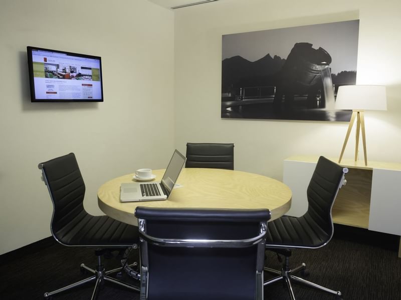 Laptop on a round meeting table in Salon E at Fiesta Inn