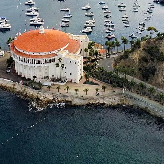 Aerial view of a round, orange-roofed building on a peninsula surrounded by boats at Catalina Island Company