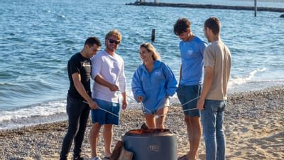 A group of friends BBQing by the beach near Falmouth Tides