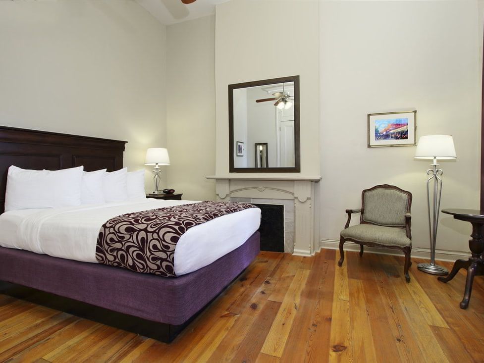 King bed & chair in Deluxe room, French Quarter Guesthouses