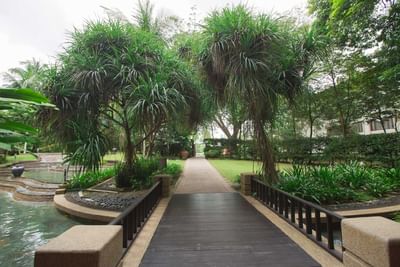 Peaceful garden path with greenery and water at The Saujana Hotel Kuala Lumpur