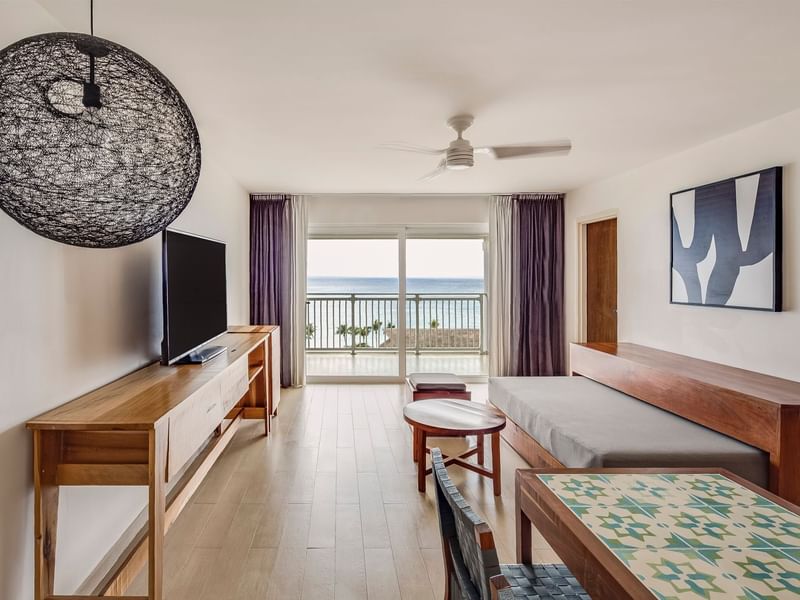 Living area with a TV, couch, and a ocean view in 2 Bedrooms Family Suite at Fiesta Americana
