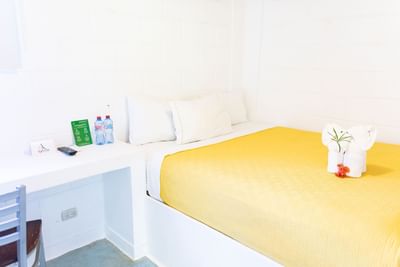 Interior view of a room with a single bed and working desk at Cha Cha Hotel