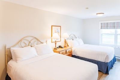 Two-Bedroom Cottage featuring beds with white linens in luxury accommodations PEI at Rodd Crowbush Golf & Beach Resort
