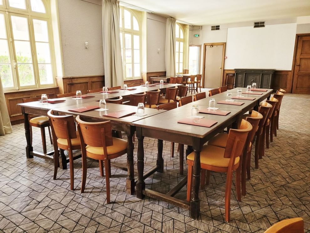 Velary Room with tables and chairs, set with menus and glasses by windows at The Originals City, Hotel Bristol