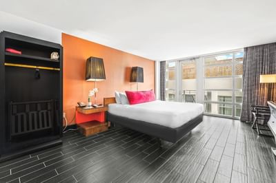 King bed with nightstands by the balcony window in Deluxe King with Balcony at Fairwind Hotel Miami