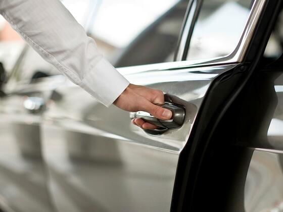 Close-up of hand holding car door handle at Dream Nashville
