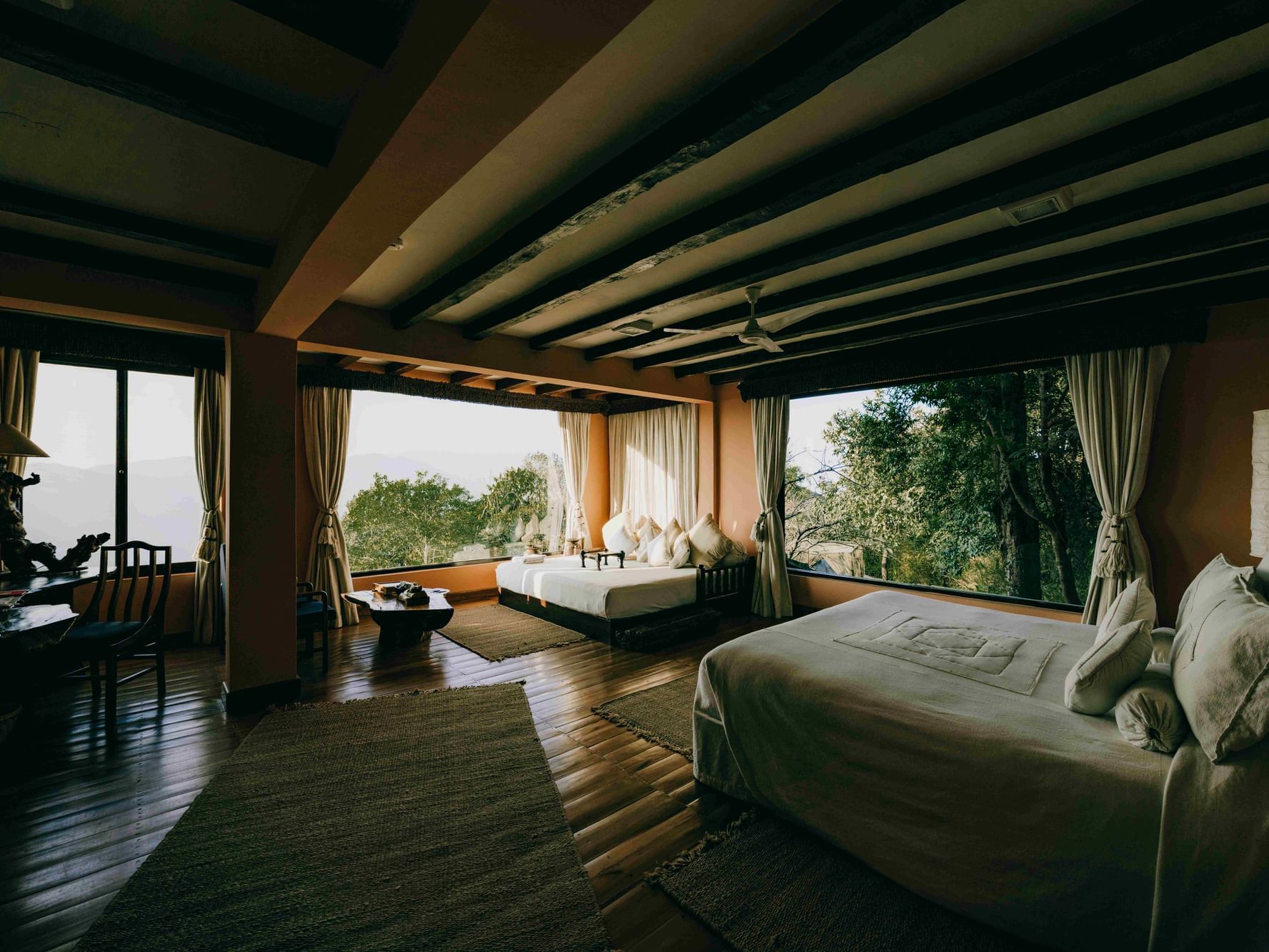 Junior Suite with Terrace with two beds and large windows offering a serene natural view at Dwarika's Himalayan Wellbeing