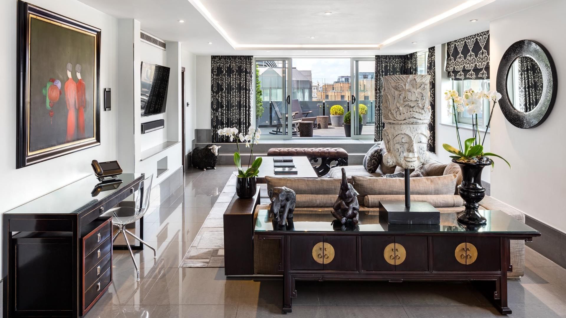 Stylish living room in The Ebony Suite at The May Fair Hotel, London, with sleek furniture and terrace-view windows