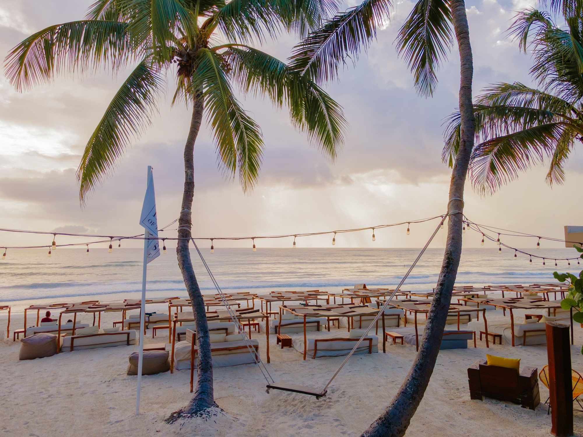 Beach beds and palm-frond shade at La Zebra Beach Club in Tulum.
