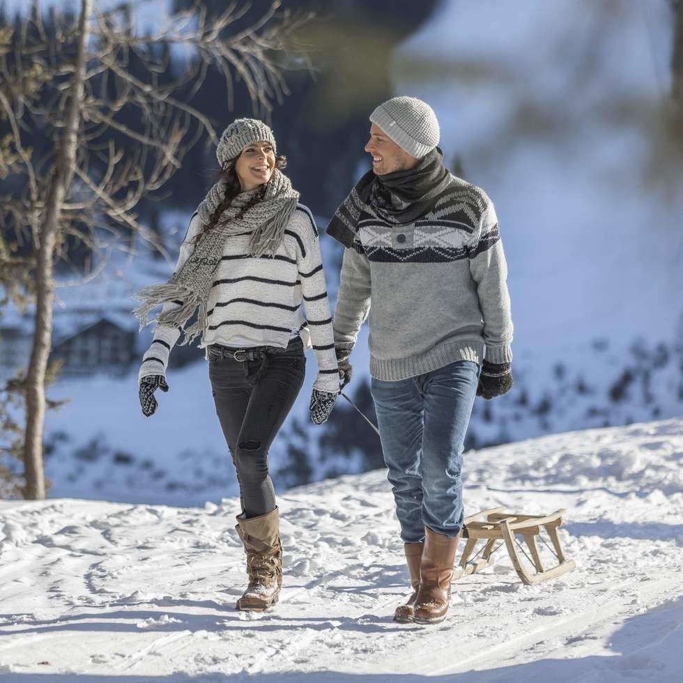 Couple getting ready for tobogganing near Falkensteiner Hotels