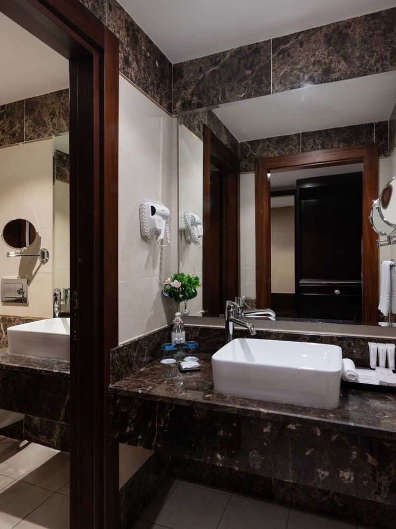 Bathroom with marble countertops, white sink, and modern fixtures in Executive One-Bedroom Suite at Warwick Hotel Jeddah