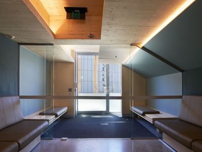 Elegant hallway with tan couches and glass doors at La Trobe University North and South Apartments.