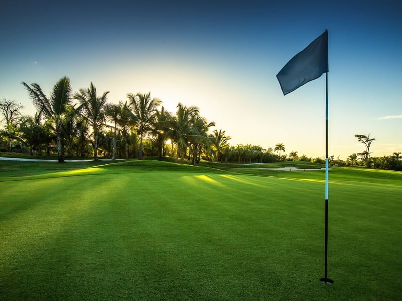 Golf hole with flag in the golf course at Live Aqua Resorts and Residence Club
