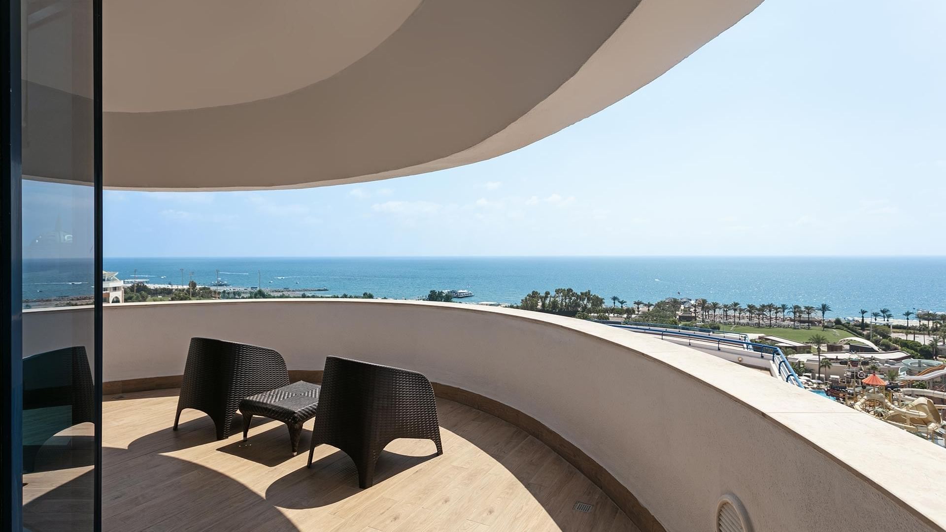 Роскошные апартаменты в Titanic Deluxe Lara – Admiral Suite с балконом, видом на море, двумя стульями и журнальным столиком.