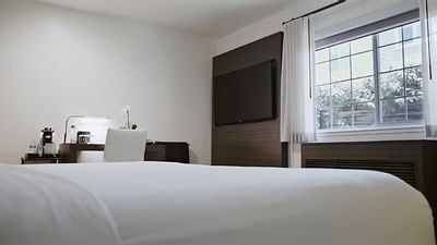 Bed, working desk & TV in a room at The Nest Palo Alto