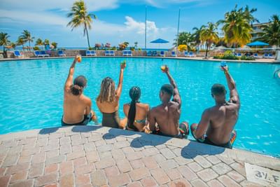 Group sitting at an edge of the pool in Holiday Inn Montego Bay