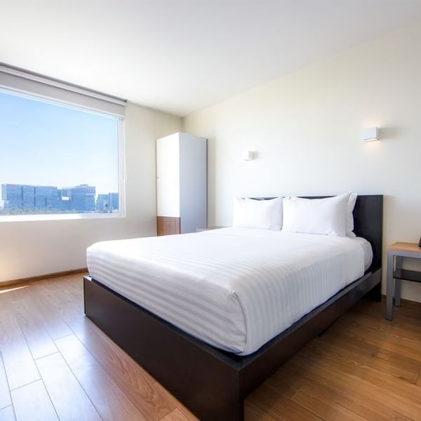 Interior of a room with a king bed at Gamma Hotels