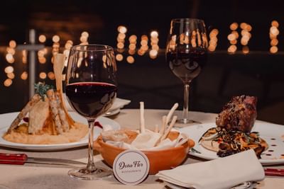 Platos servidos con vino en Dona Flor en Panoramic Grand