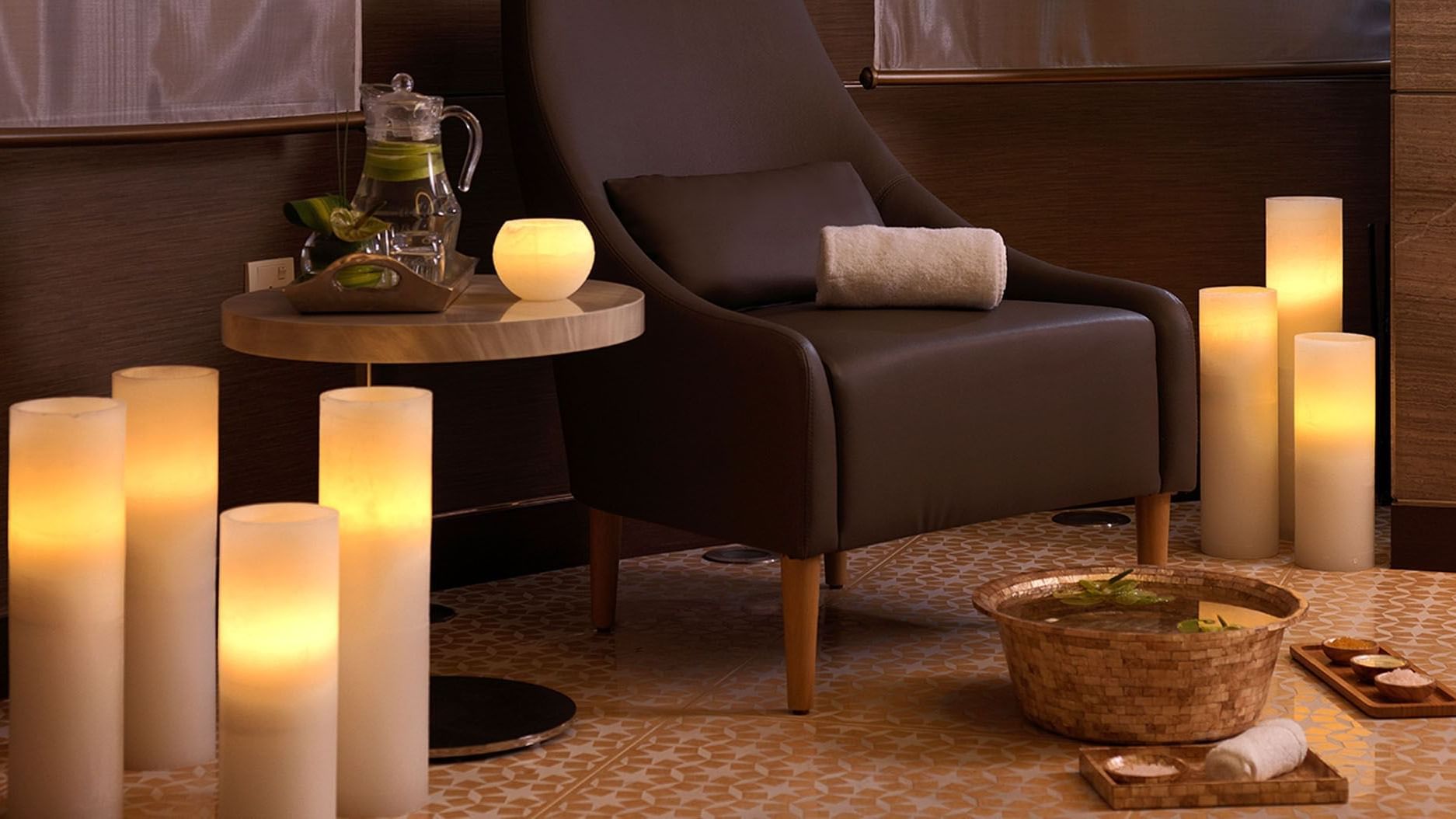 Comfy chair adorned with lit candles with a warm ambiance at DAMAC Maison Cour Jardin 