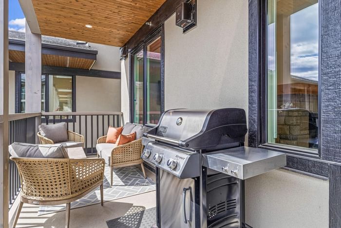 Modern outdoor patio with a grill and wicker chairs at Spring Creek Vacations