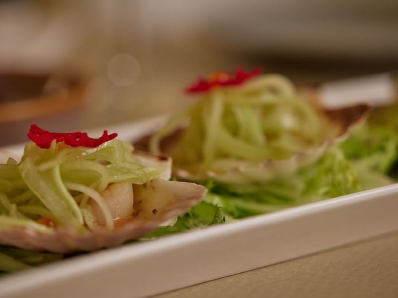 Two scallop appetizers with garnish served in Modo Mio at Crown Promenade Perth