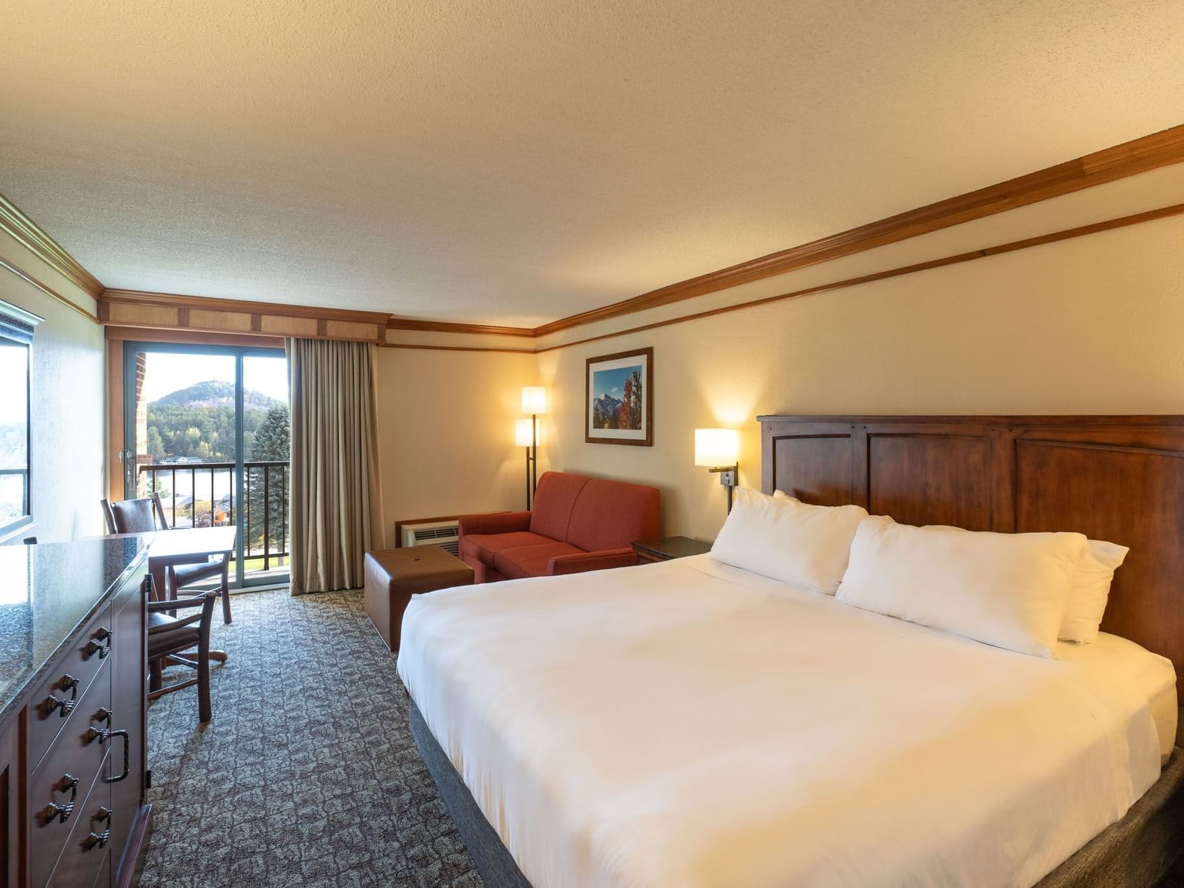 King room with a comfortable bed, couch, and a balcony at Lake Placid Club Grandview